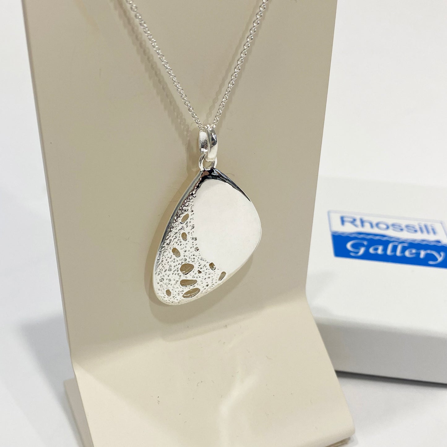 Silver Open Pendant With A Textured Surface.